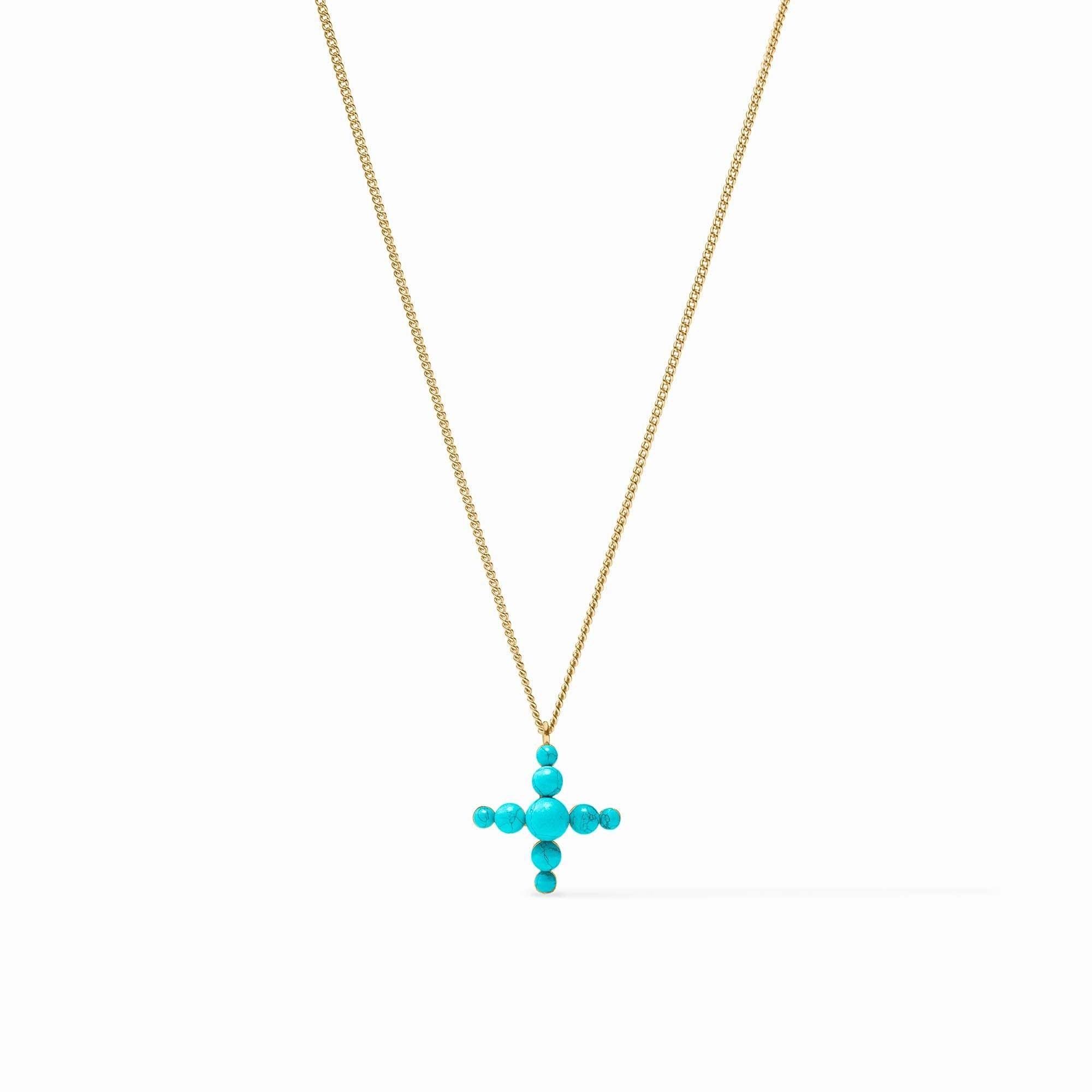 Turquoise blue reconstituted stone cross pendant on a delicate gold curb chain necklace.
