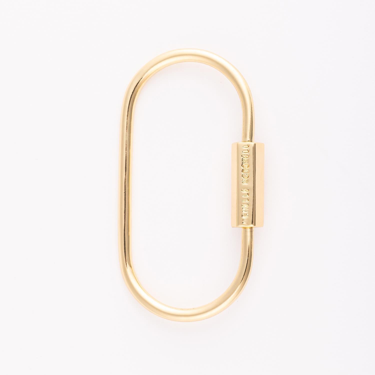Charm Bag Carabiner: an 18k gold-plated brass carabiner with a smooth silhouette and polished finish.