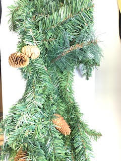 Close-up of an Evans Pine Garland featuring green artificial needles and small brown pinecones.
