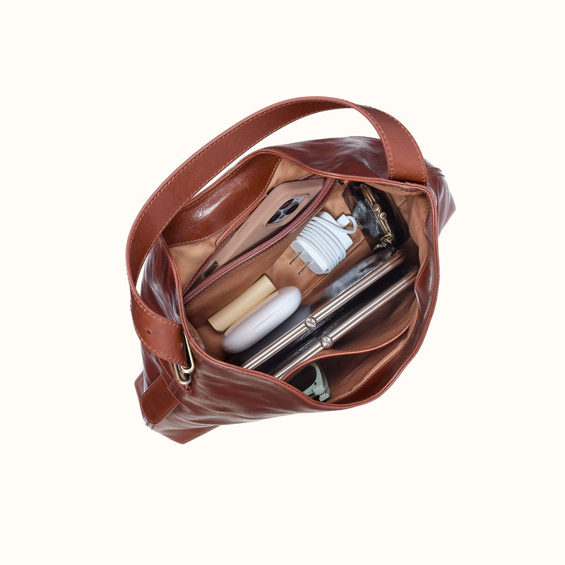 Interior view of the Atlas Hobo Bag in Pecan Ridge leather, filled with daily essentials.