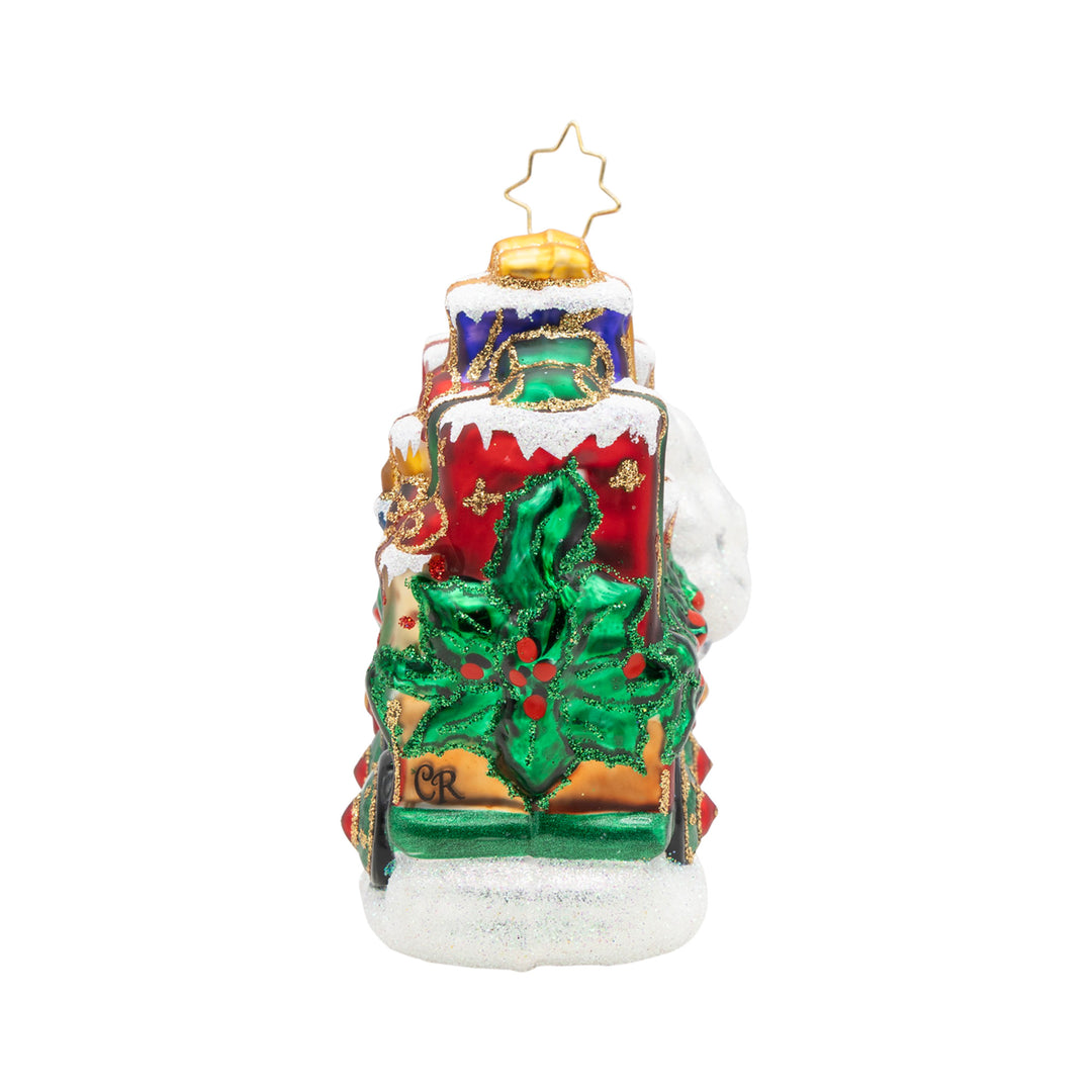 Back view of Yuletide Express glass ornament showing stacked gifts and a large green holly leaf.