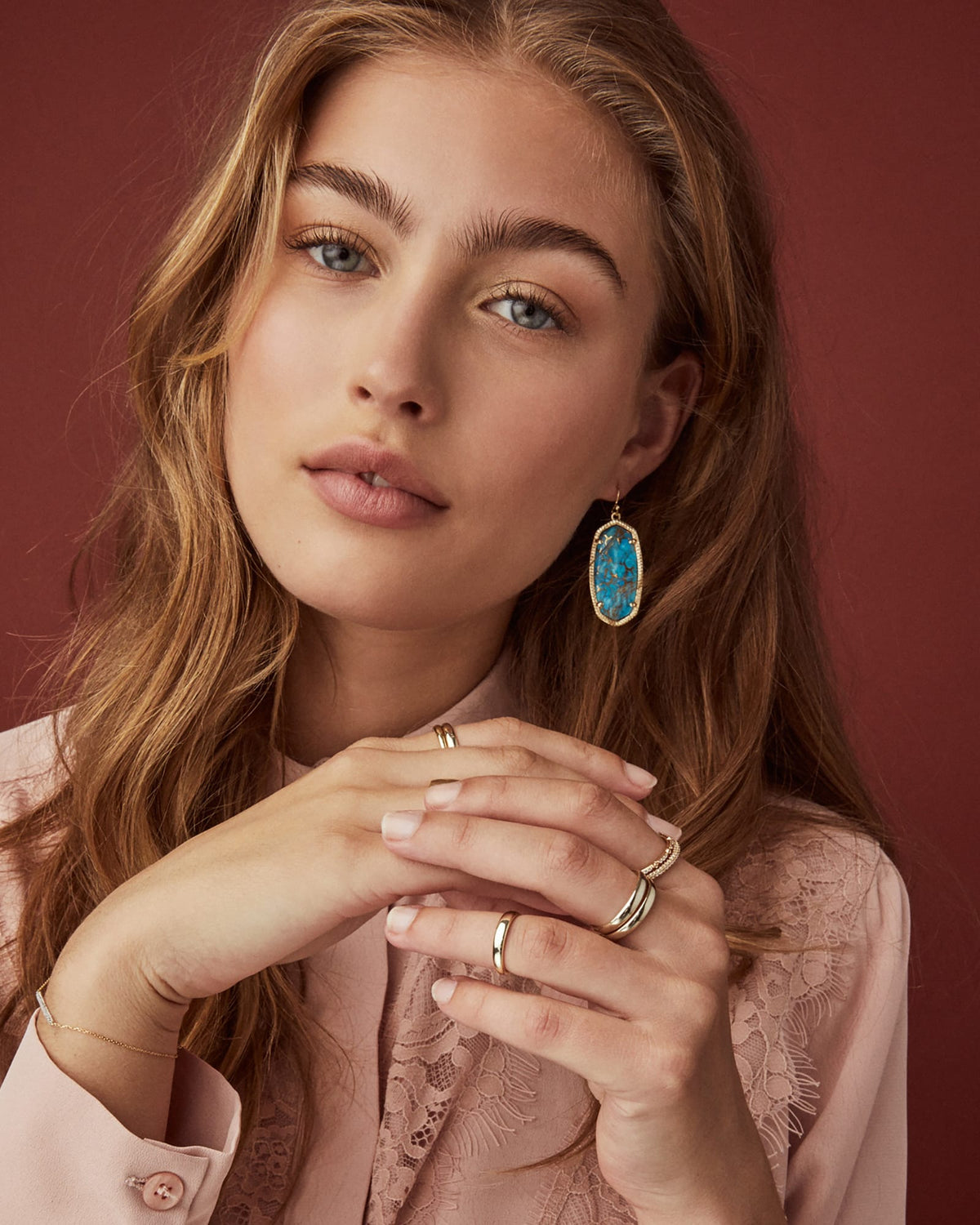 Model wearing Elle Drop Earrings in 14k yellow gold over brass with turquoise stones.
