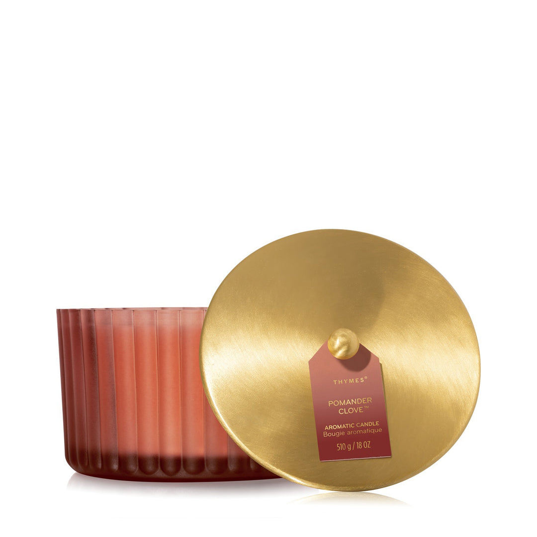 Thymes Pomander Clove 3 Wick Candle in a fluted red glass jar with a gold metal lid.