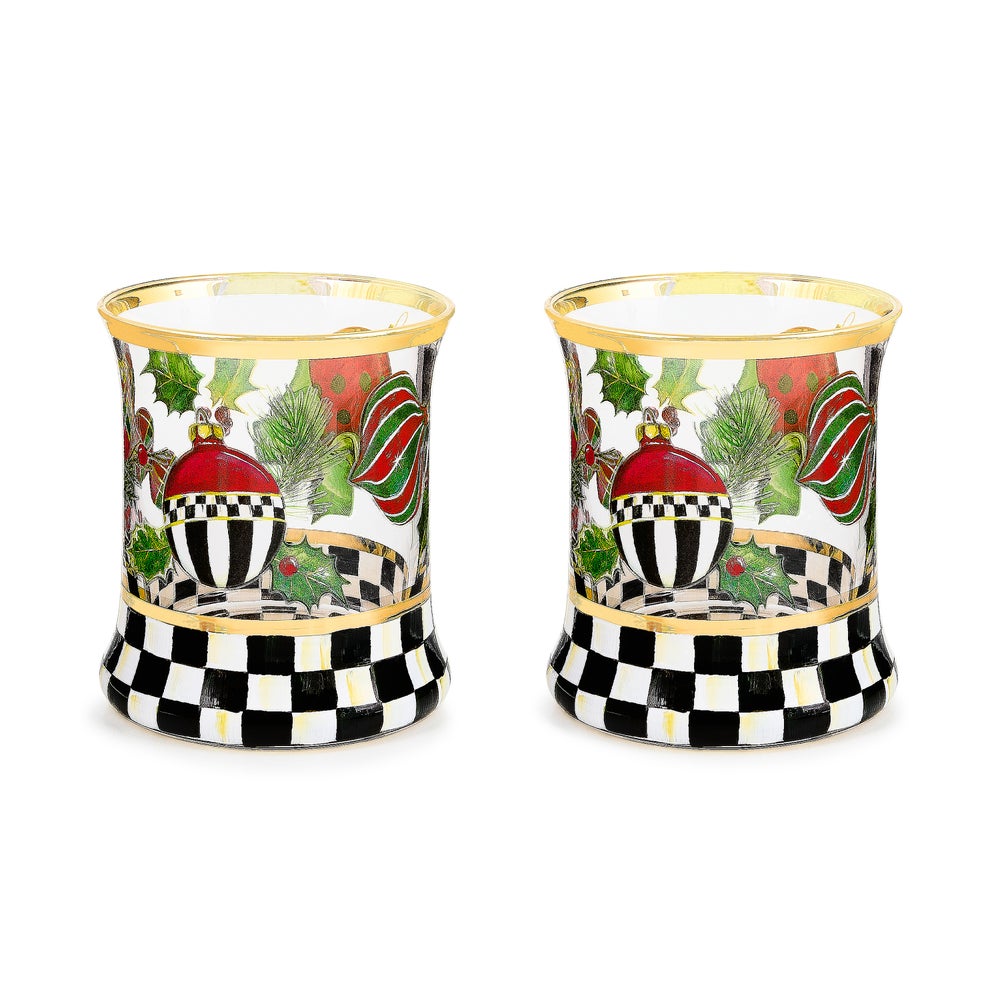 Two glass tumblers with hand-painted Christmas ornaments, holly, and a black and white checkered base