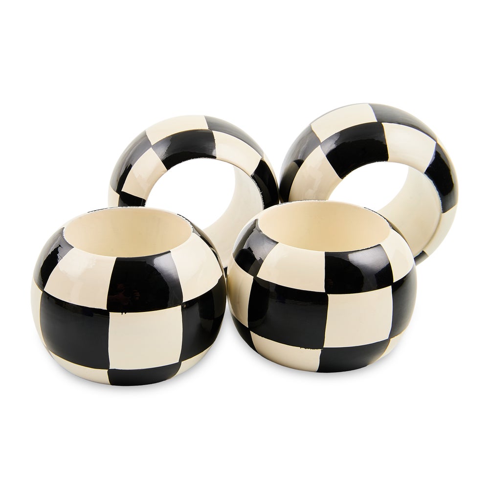 Set of four wooden napkin rings featuring a hand-painted black and white checkered pattern.
