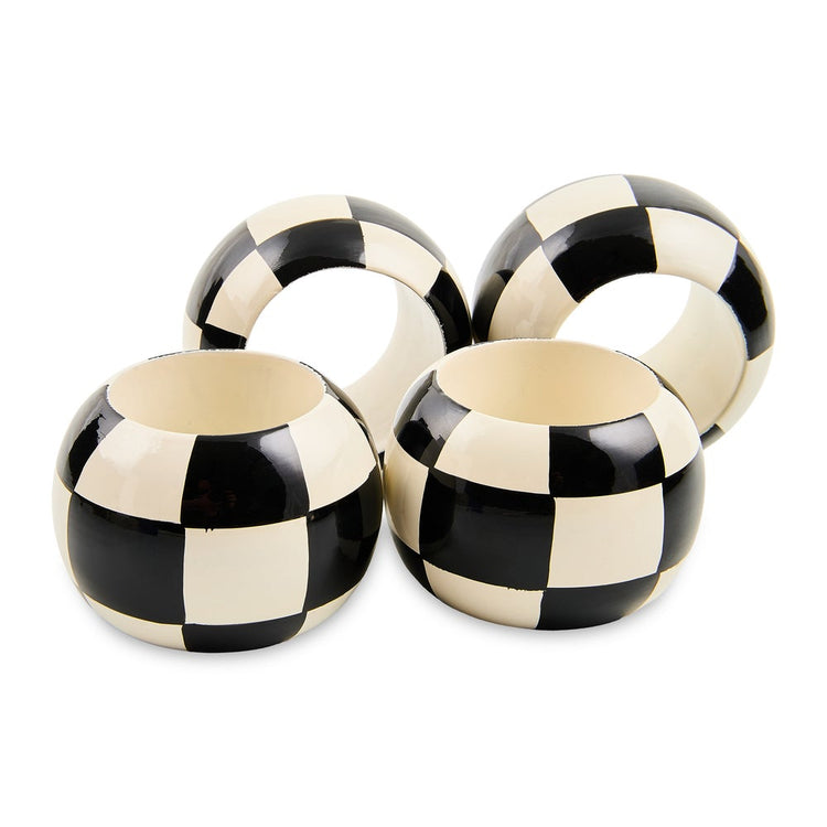 Set of four wooden napkin rings featuring a hand-painted black and white checkered pattern.