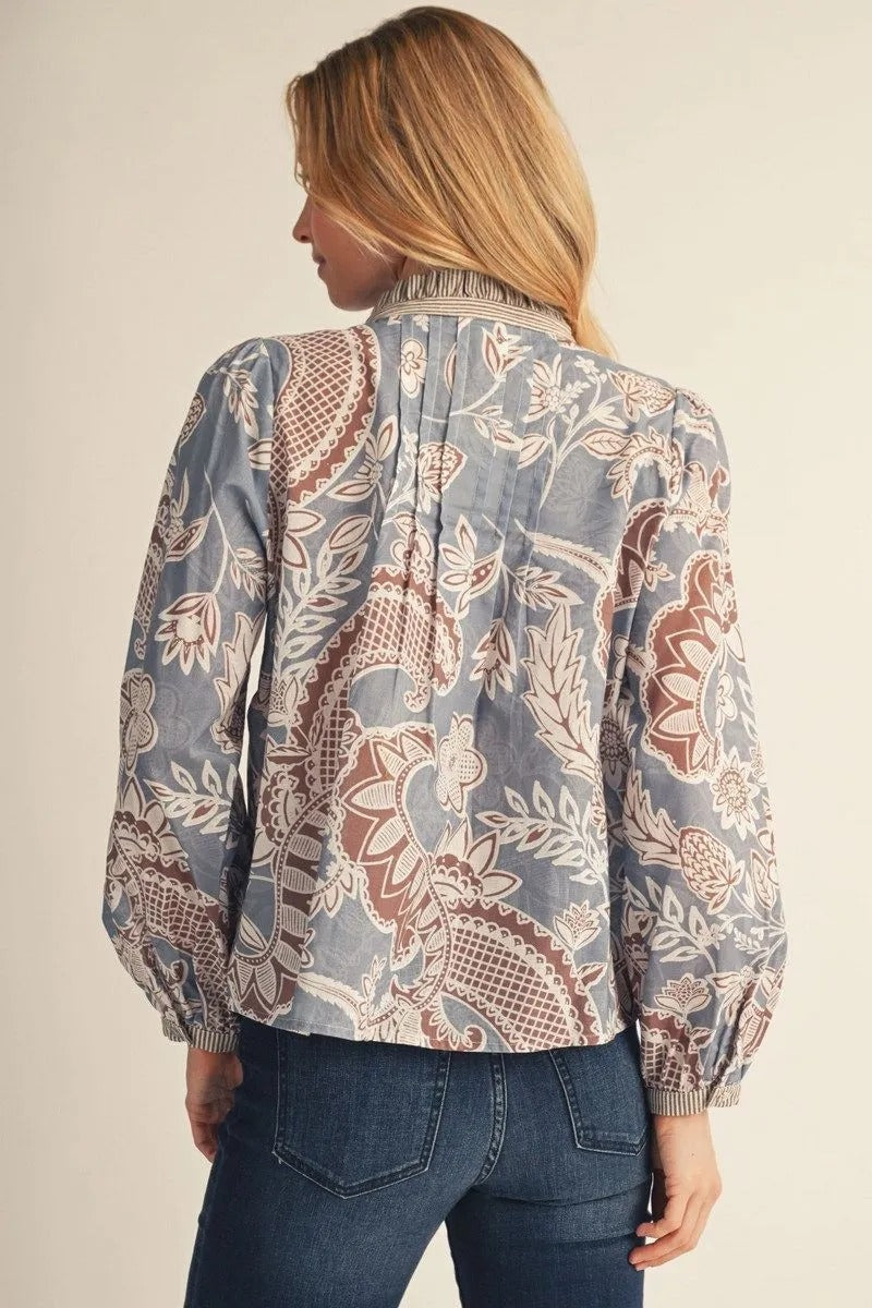 Back view of a woman wearing the Adeline long-sleeve boho paisley floral top in blue and brown.