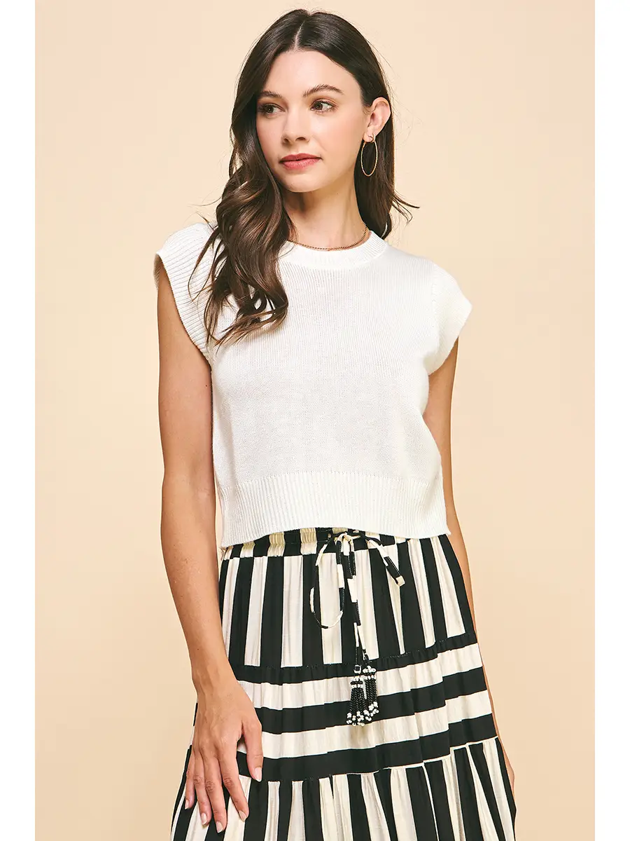 Woman wearing a white Kathy Cap Sleeves Knit Top with a round neck and ribbed hem.