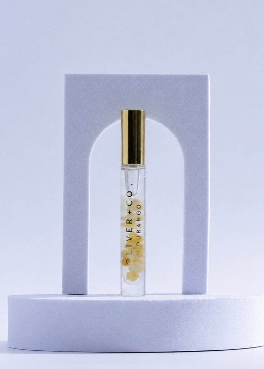 Oliver + Co. Durango Bougie Stick roll-on perfume with yellow crystals in a clear glass vial.