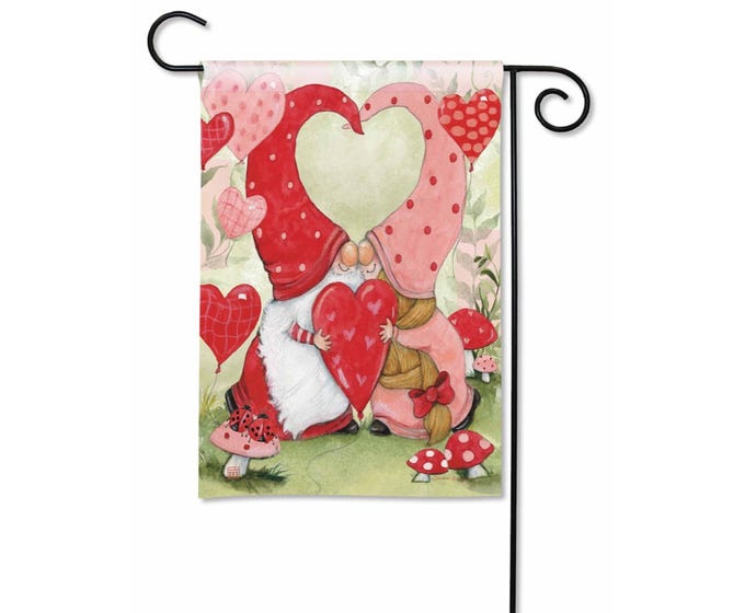 Garden flag with two gnomes hugging a heart, surrounded by hearts and mushrooms.