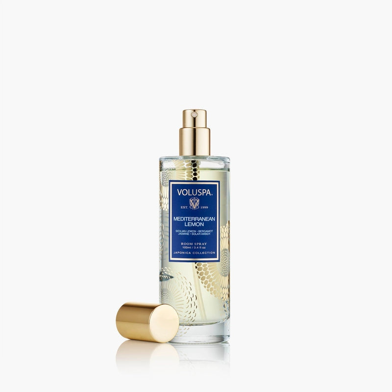 Voluspa Mediterranean Lemon Room Spray in a clear glass bottle with gold accents and cap.