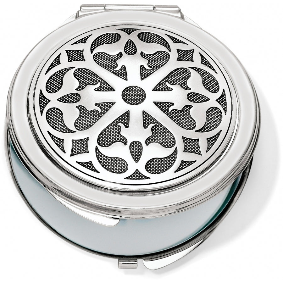 Silver plated compact mirror with pressure retractable closure and one side offering 2.5x magnification.