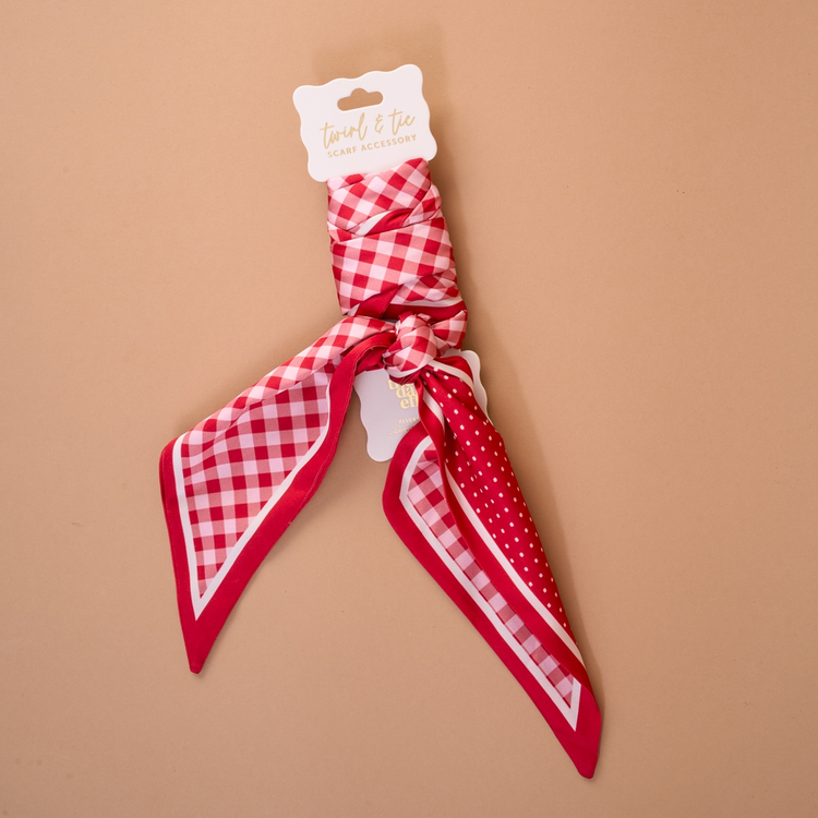 Red and white gingham and polka dot satin Twirl & Tie Scarf Accessory on a display card.