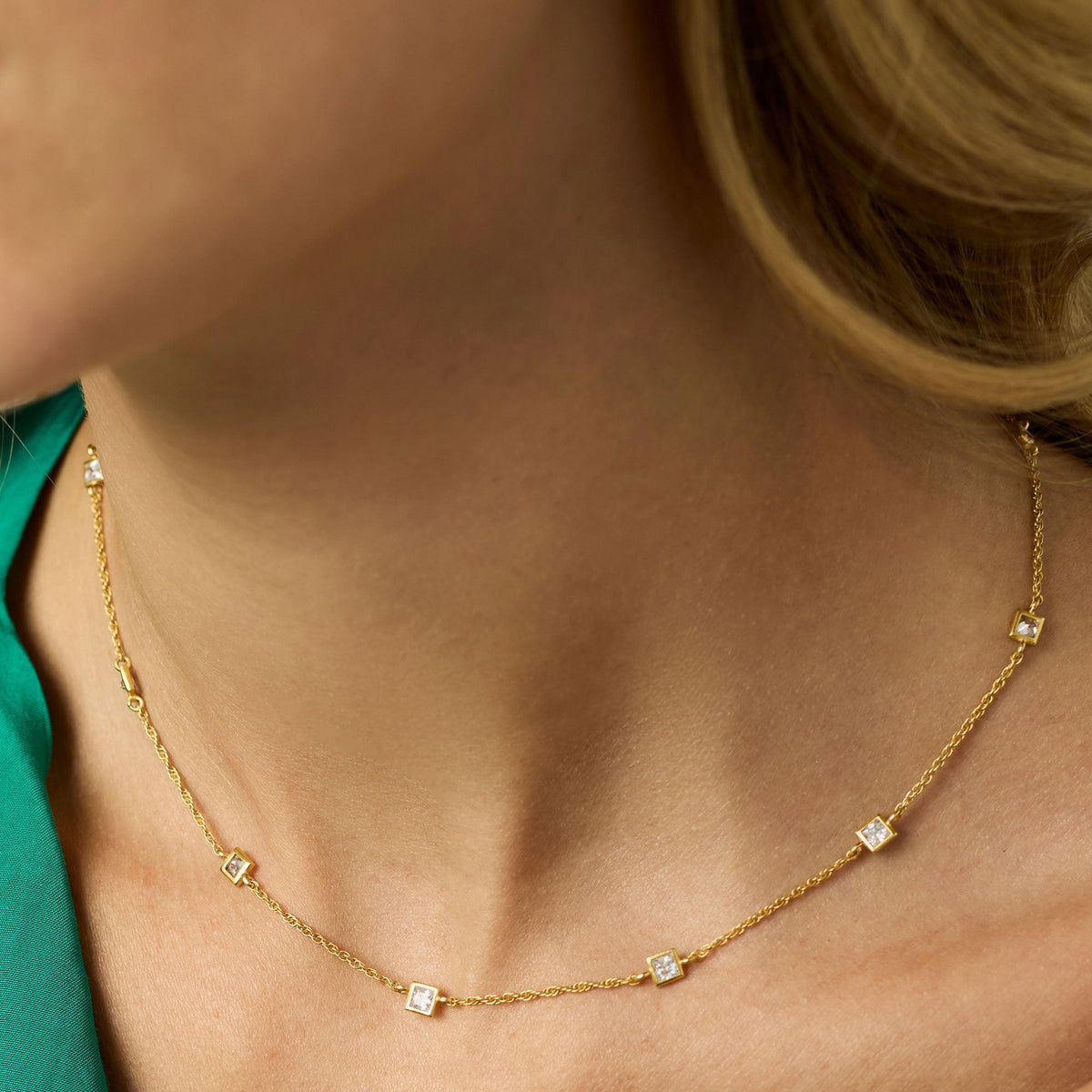 Delicate gold-plated station necklace with cubic zirconia stones on an adjustable chain.