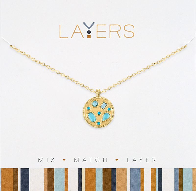 Gold chain necklace with a circular gold pendant featuring inlaid aquamarine gemstones.
