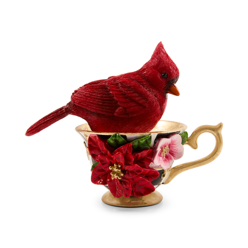 A red cardinal figurine sitting inside a decorative teacup with floral accents and a gold handle.