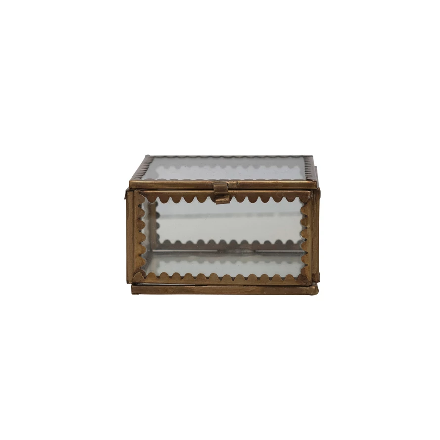Small square brass and glass display box with decorative scalloped metal edges and a front latch.