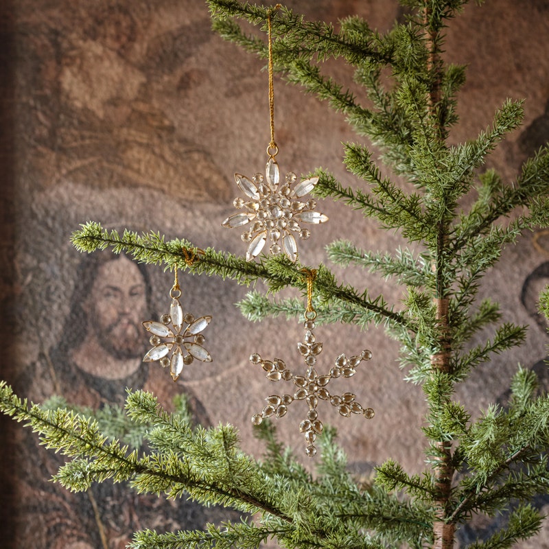 Metal snowflake ornament with glass jewels in gold color