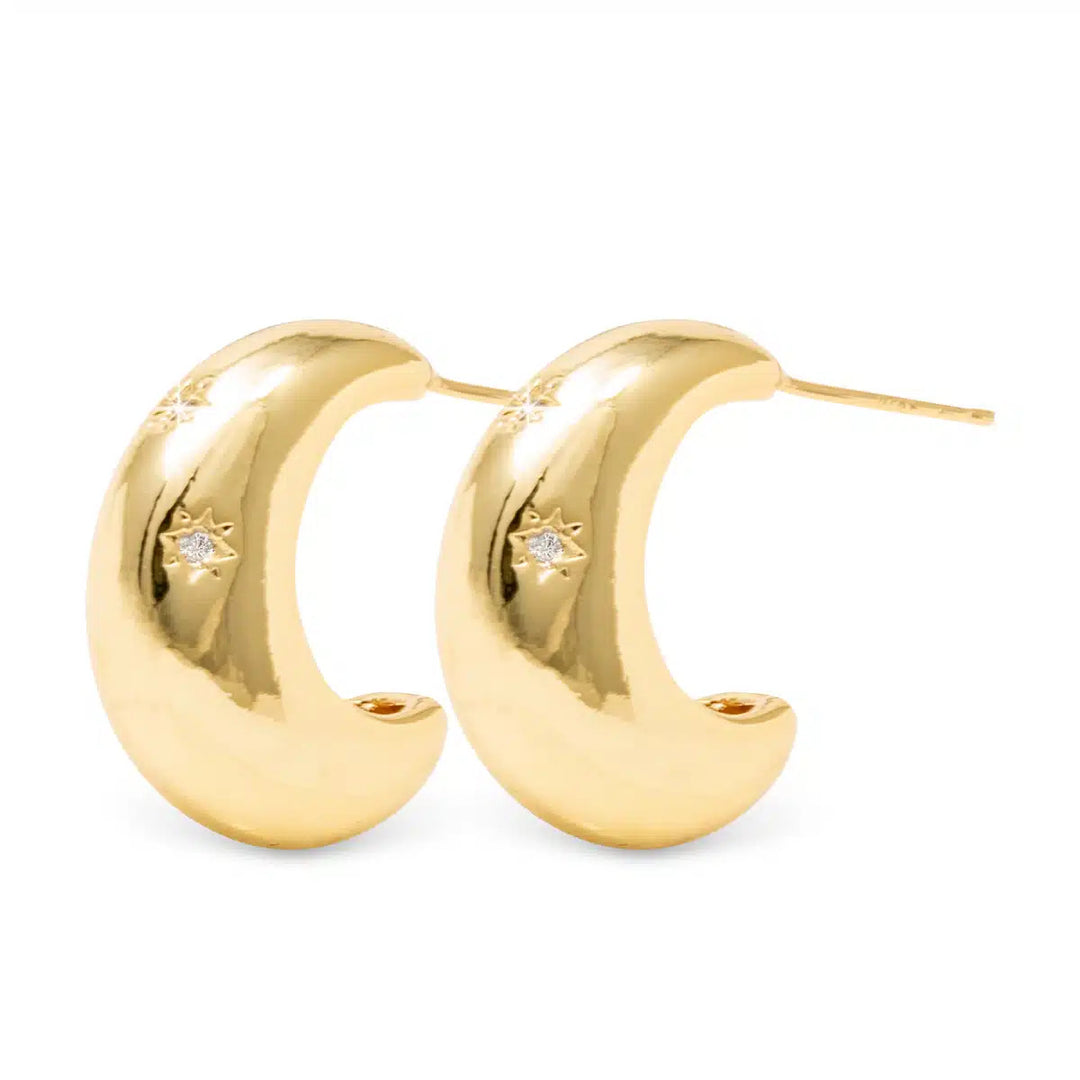 Paisley polished gold crescent huggie earrings with starburst cubic zirconia accents.