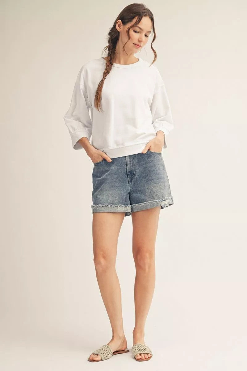 Millie casual top in washed fabric with drop shoulders, raw cut edges, reversed stitching, and a relaxed silhouette.