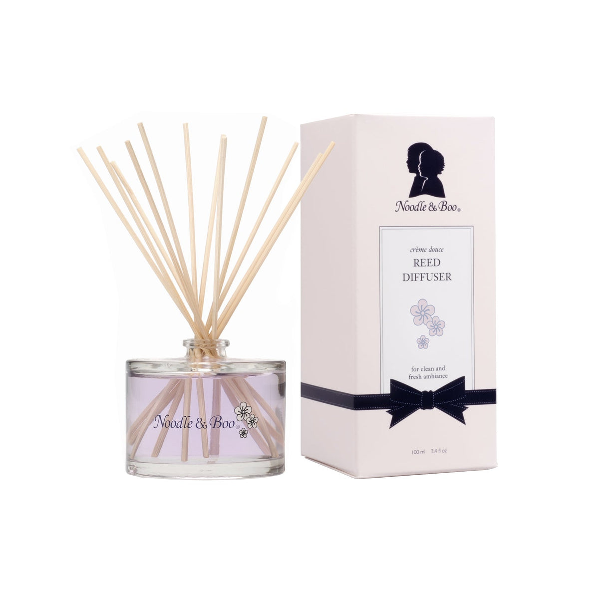 Noodle & Boo Reed Diffuser in a glass bottle with wooden reeds next to its white gift box.