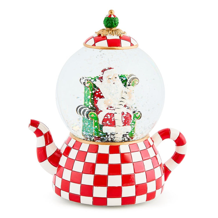 Check It Out Teapot Snow Globe featuring Santa in a chair on a red and white checkered teapot base.