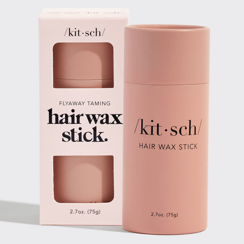 Solid hair wax stick in a biodegradable paper tube with natural brown color.
