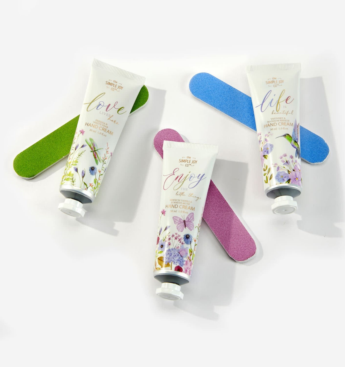 Floral paper gift box with ribbon bow containing scented hand cream and glittery nail file