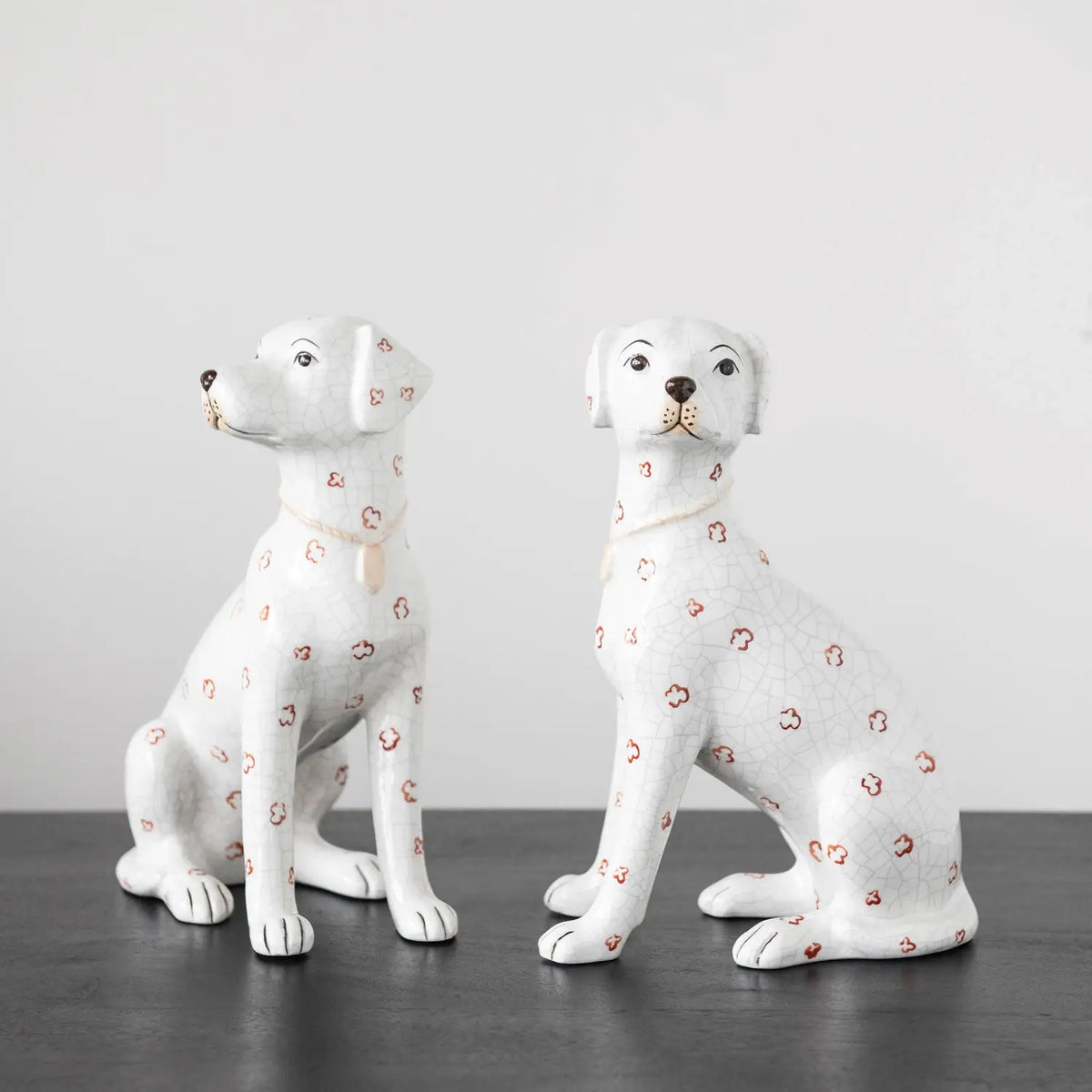Hand-painted ceramic dog figurine with antique crackle finish in cream color featuring rust-colored spots.