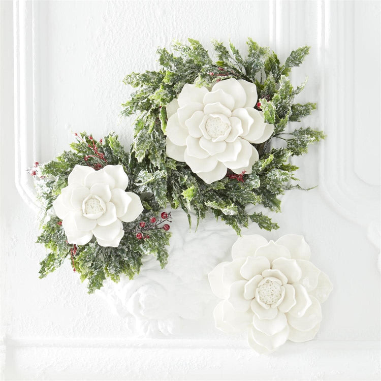 Glossy white ceramic wall hanging shaped like a stylized flower with smooth curves.