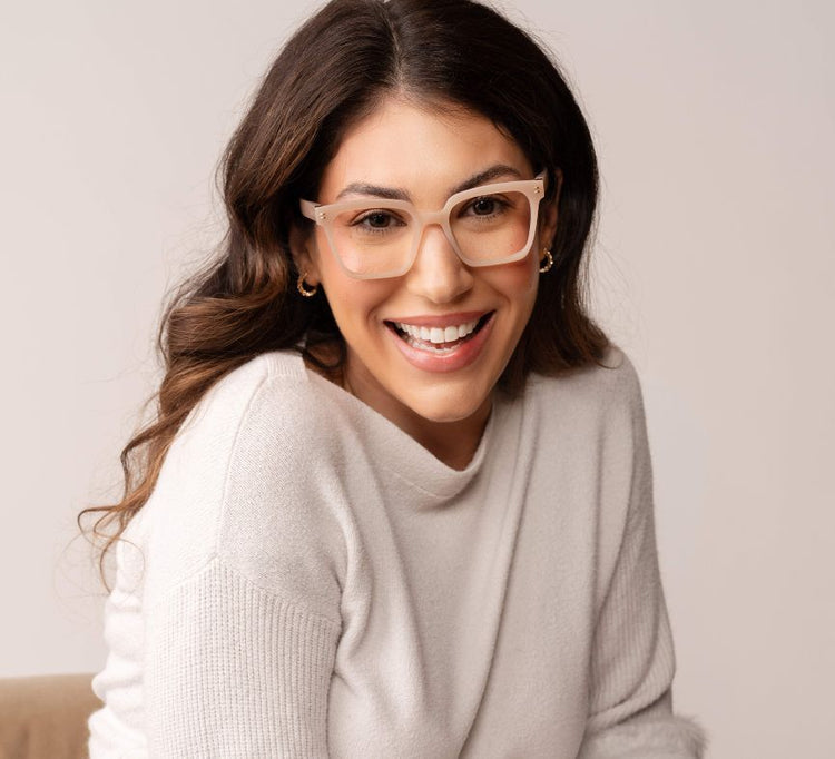 Woman wearing Montage square-frame blue light glasses in a light pink recycled material.