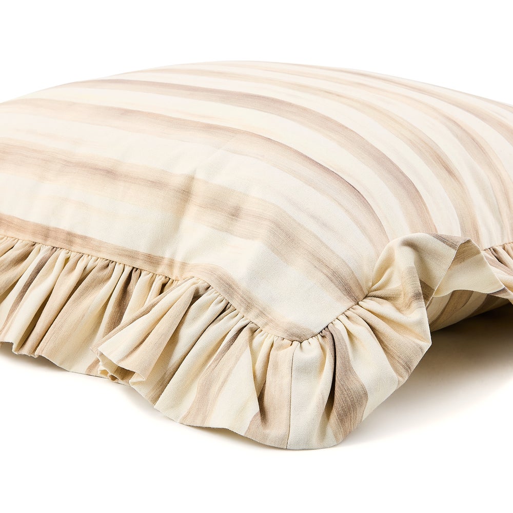 Close-up of a mocha and cream striped cotton throw pillow with a ruffled edge.