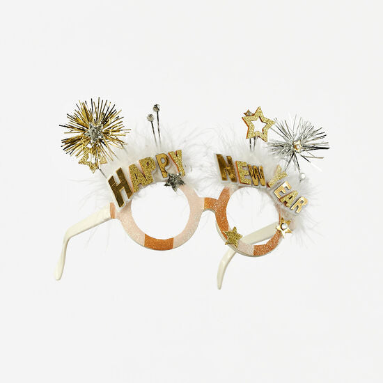 Glittery gold and silver New Year glasses with white feathers, stars, and tinsel bursts.