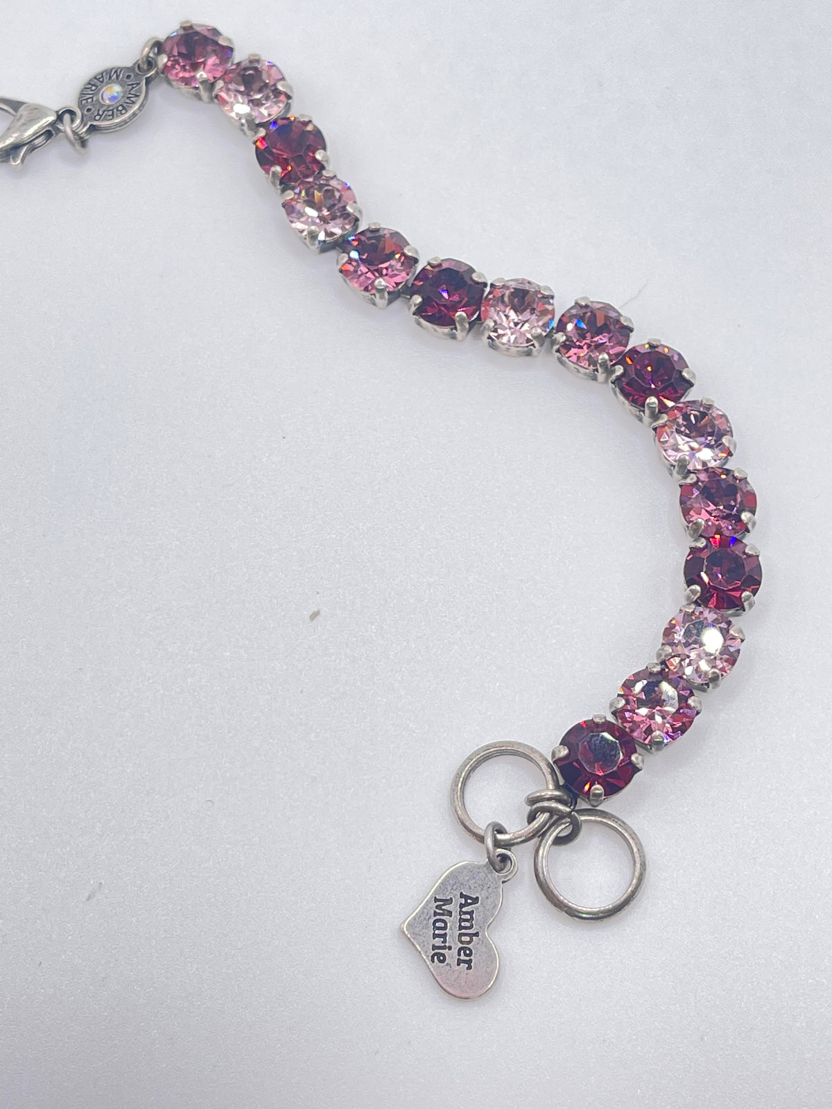 Amber Marie bracelet with pink and red crystal stones and a heart-shaped charm.