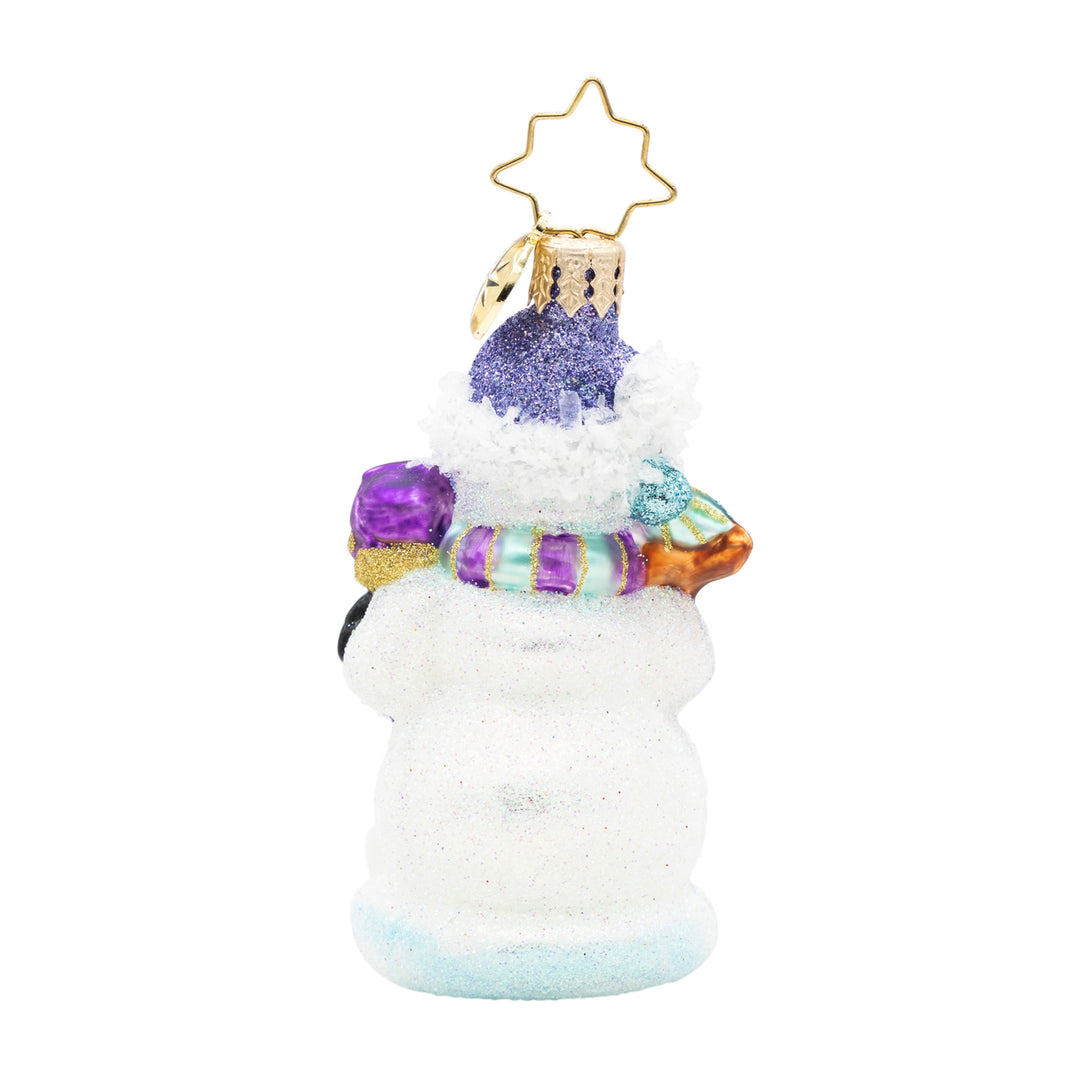 Back view of a glittery glass snowman ornament wearing a purple hat and striped scarf.