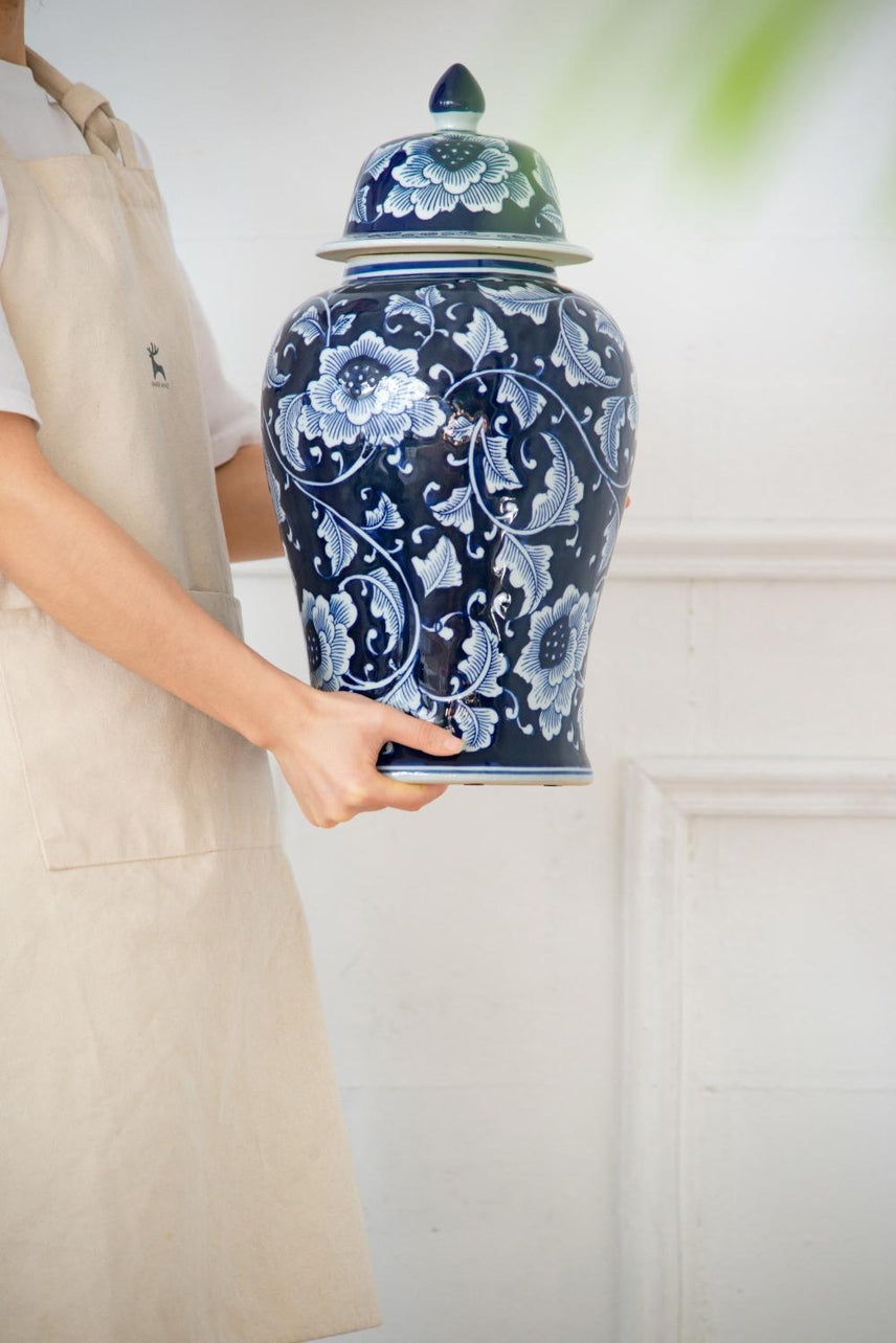 Medium Aline Ginger Jar in blue and white porcelain with floral patterns, held by a person.