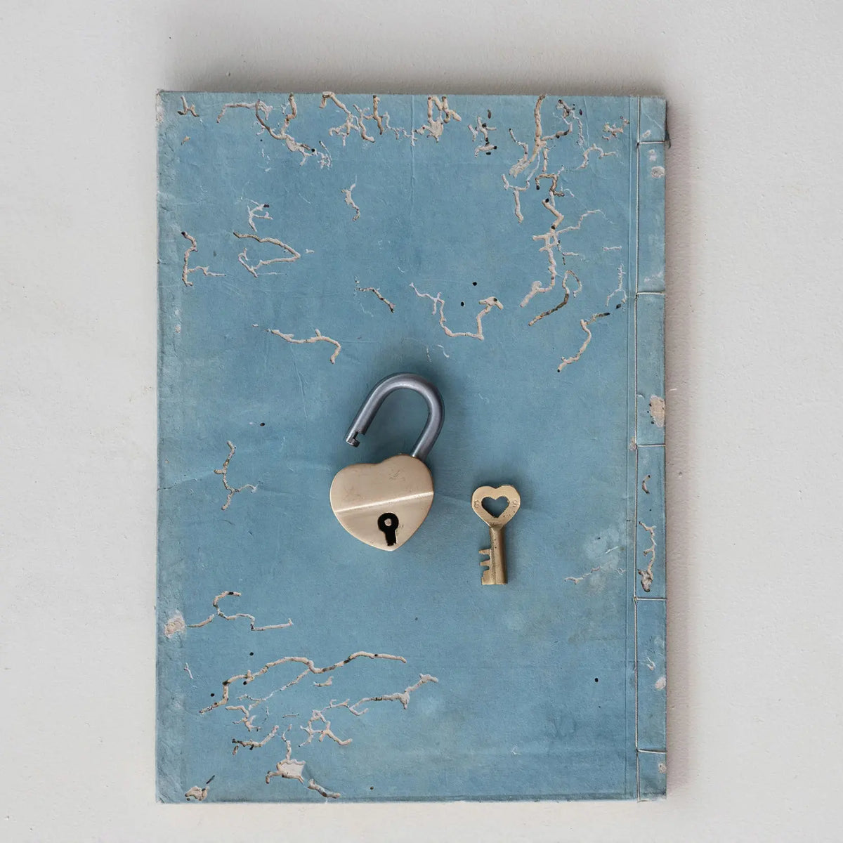 Heart-shaped brass lock with matching heart key featuring intricate detailing