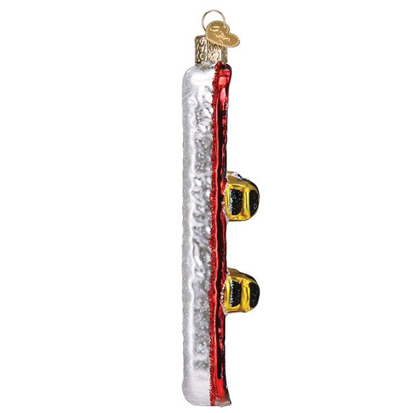 Side view of a glass snowboard Christmas ornament with a red base and yellow bindings.