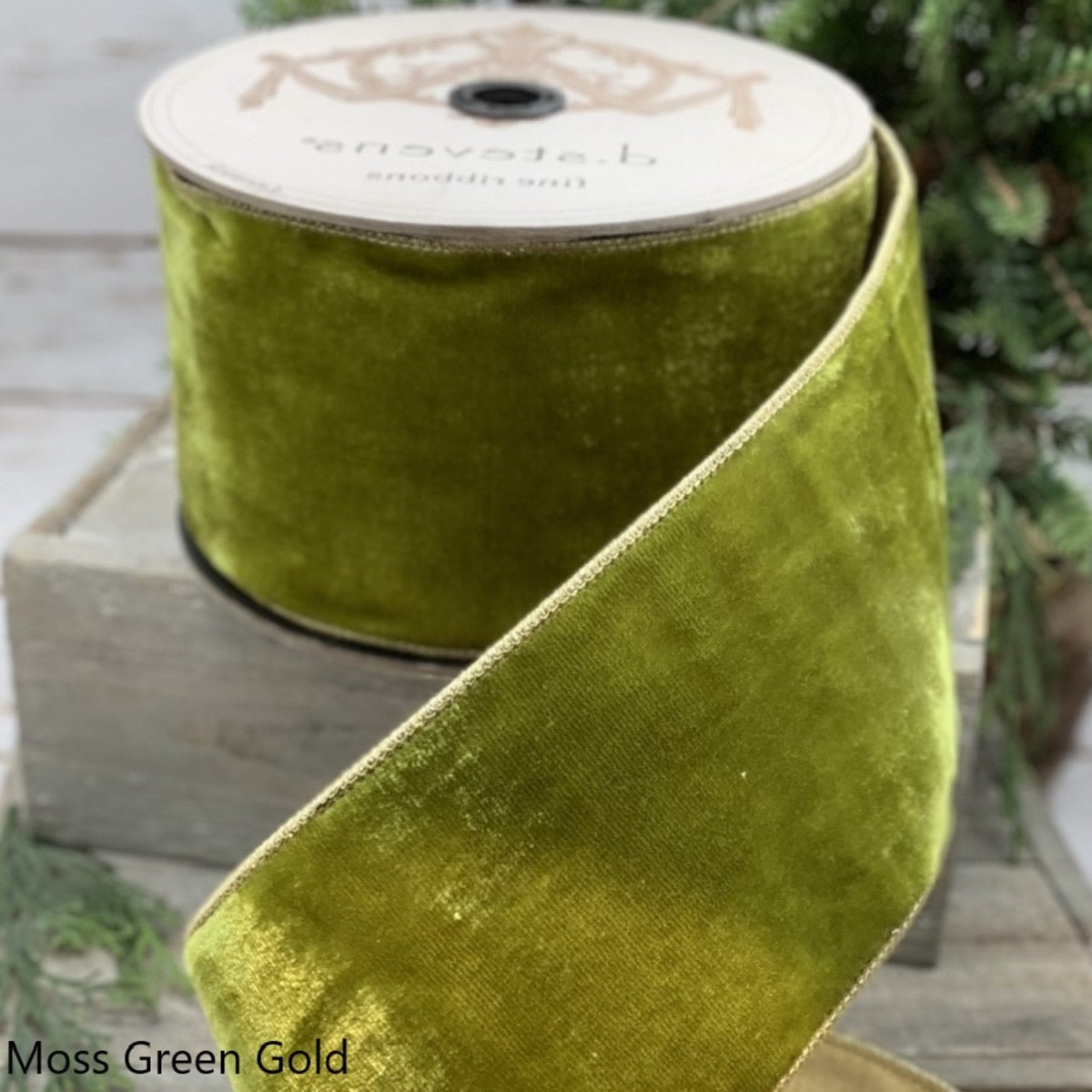 A roll of 4-inch wide moss green velvet ribbon with gold-finished edges.