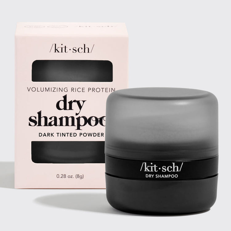Dark tinted volumizing rice protein dry shampoo powder in a travel-friendly container with built-in puff.