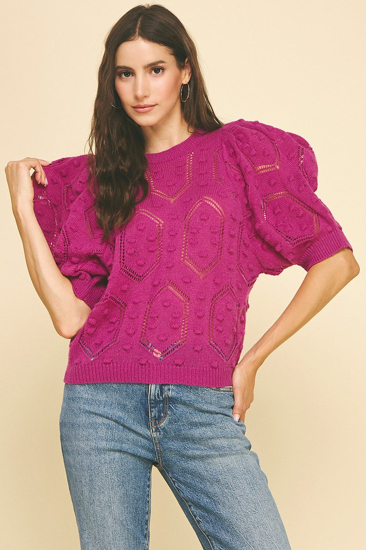 Woman wearing a magenta Alexia round neck sweater with puffed sleeves and embroidered details.