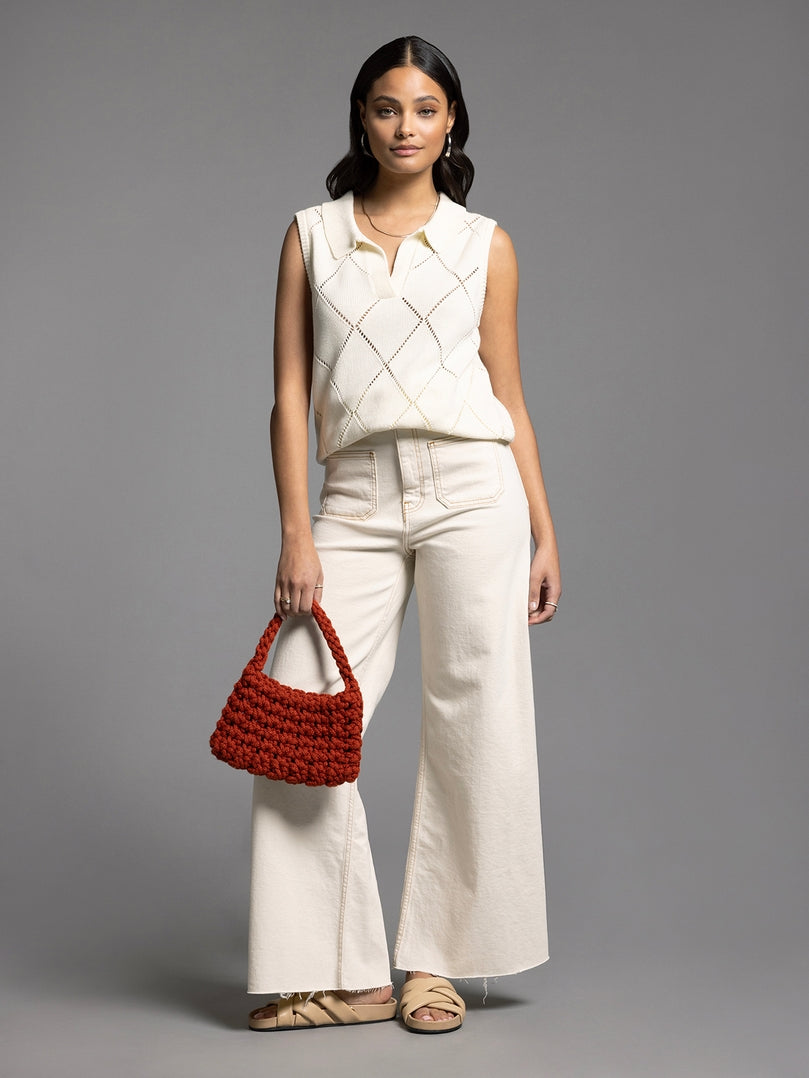 Woman wearing the Aria Collared Sleeveless Knit Top in cream with an argyle pattern.