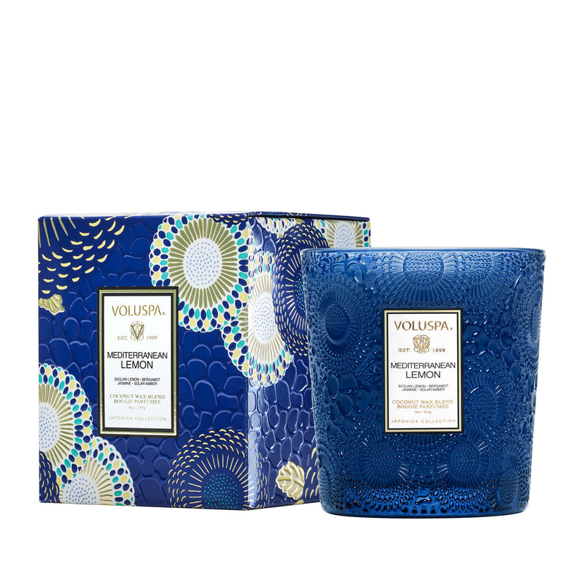 Voluspa Mediterranean Lemon 9oz. Classic Candle in a blue embossed glass jar next to its box.