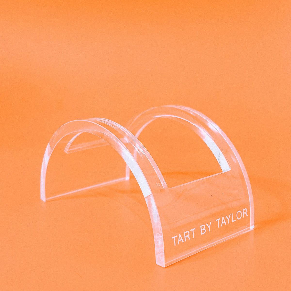 U-Shape Coaster Display holding four round coasters in a clear acrylic stand with black base.