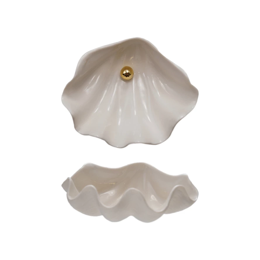 Two views of a white stoneware clam shell shaped dish, one showing a gold pearl detail inside.