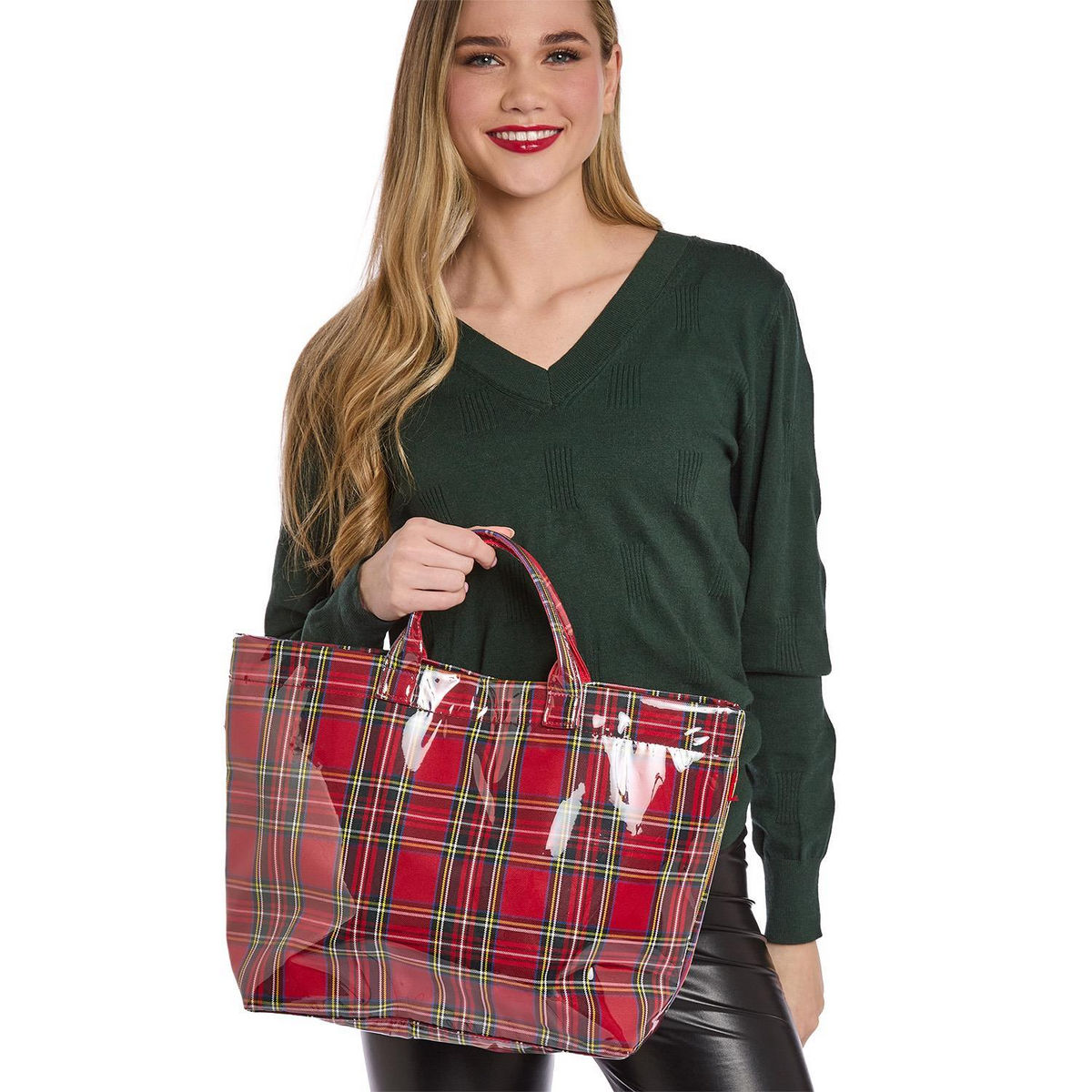 A woman holding a red Tartan Tote bag with a glossy PVC finish and a spacious interior.