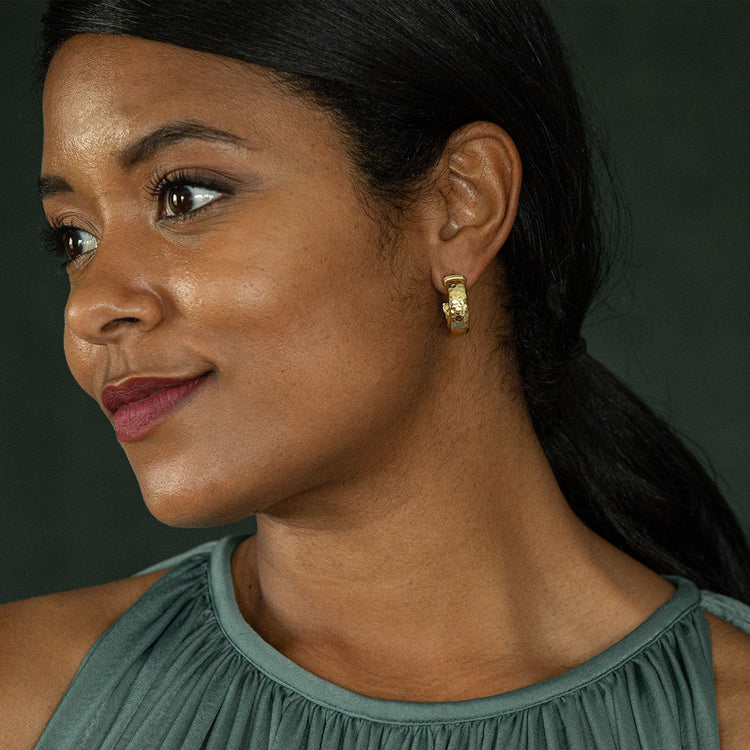 A woman wearing the Cleopatra Classic Small Hoop Earrings in hammered gold.