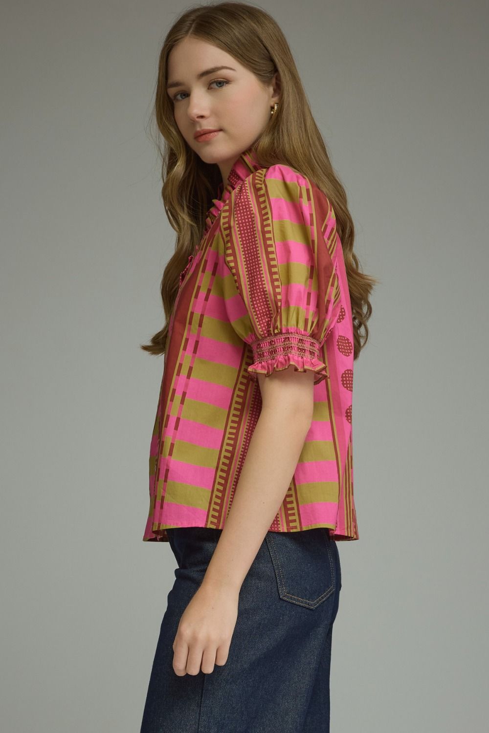 Woman wearing the Athena Mixed Print Short Puff Sleeve Top in pink and olive stripes with jeans.
