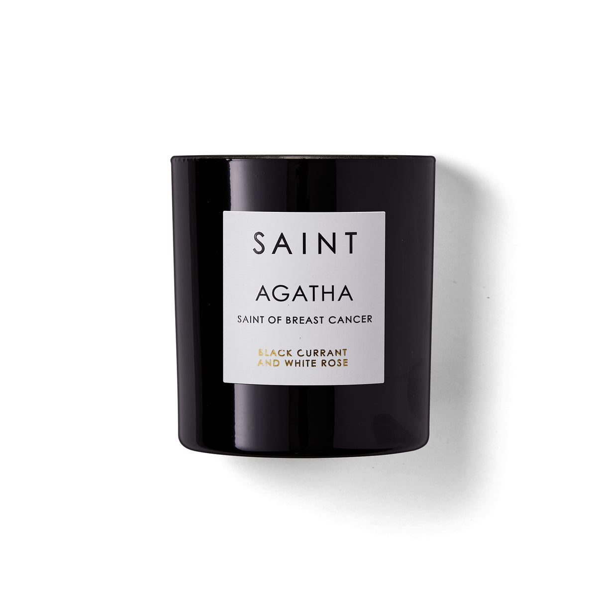 Lit white Saint candle in a glass jar with an embedded coin.