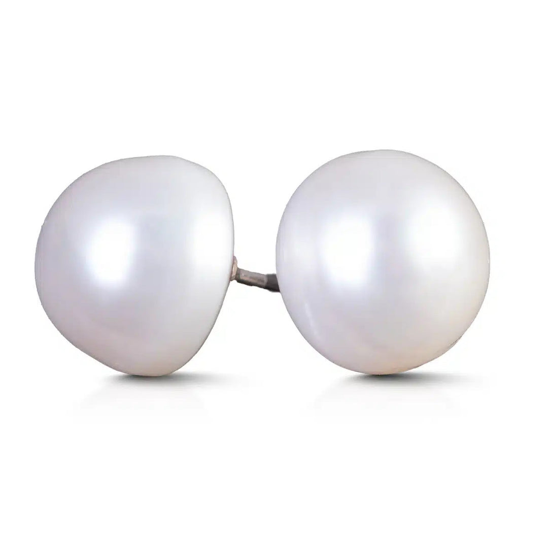 A pair of natural white button-shaped pearl stud earrings with silver posts.